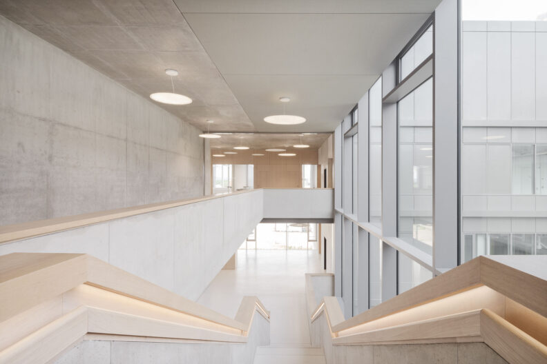 Innenperspektive Foyer angrenzend an doppelgeschossige Galerie mit repräsentativer Treppe, Albert-Ludwigs-Universität Freiburg, Neubau Forschungsgebäude IMBIT (Institute for Machine-Brain Interfacing Technology)