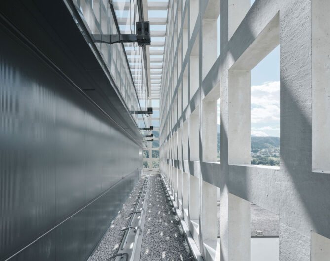 Außenperspektive Zwischenraum zwischen Gebäudehülle und vorgestellter Fassade des, Gutmann Pellets Speicher - Transformation eines Silo