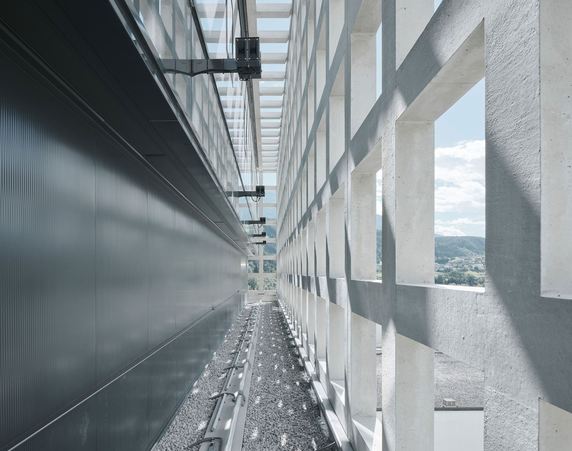 Außenperspektive Zwischenraum zwischen Gebäudehülle und vorgestellter Fassade des, Gutmann Pellets Speicher - Transformation eines Silo