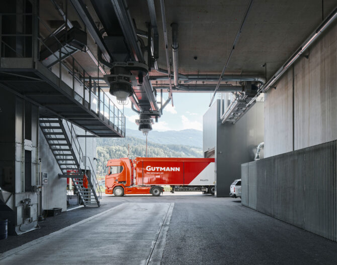 Außenperspektive überdachte Raum mit Ausblick auf Anlieferung des Gutmann Pellets Speicher - Transformation eines Silo