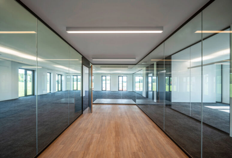 Innenperspektive transparente, durch Glaswände getrennte Büroräumlichkeiten im Bürogebäude in Gilching