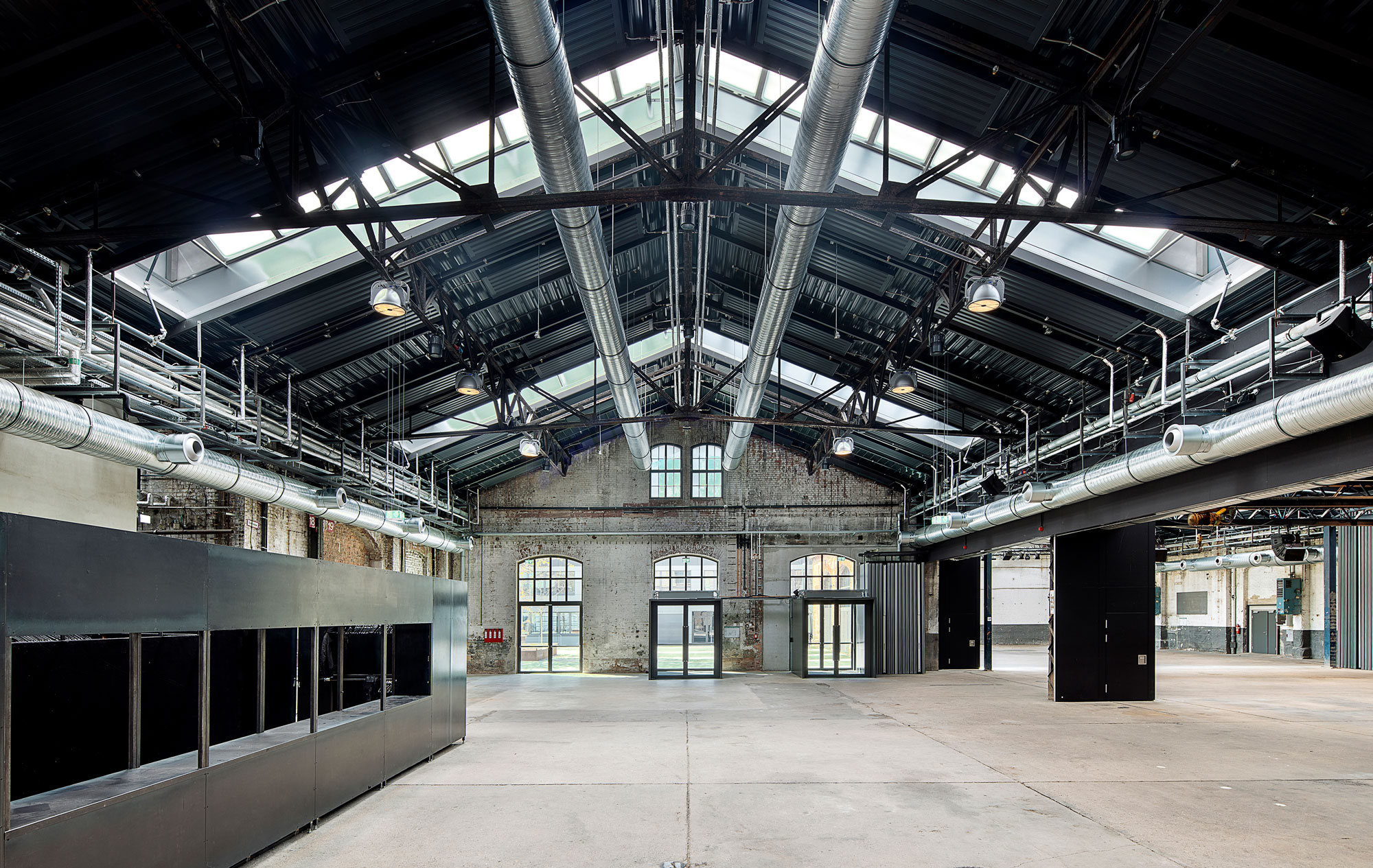 Innenraumperspektive Eingangsbereich des Hallenraums mit eingestellten Funktionskuben und flexibler Trennwand zur 4-Teilung der Wagenhallen Stuttgart