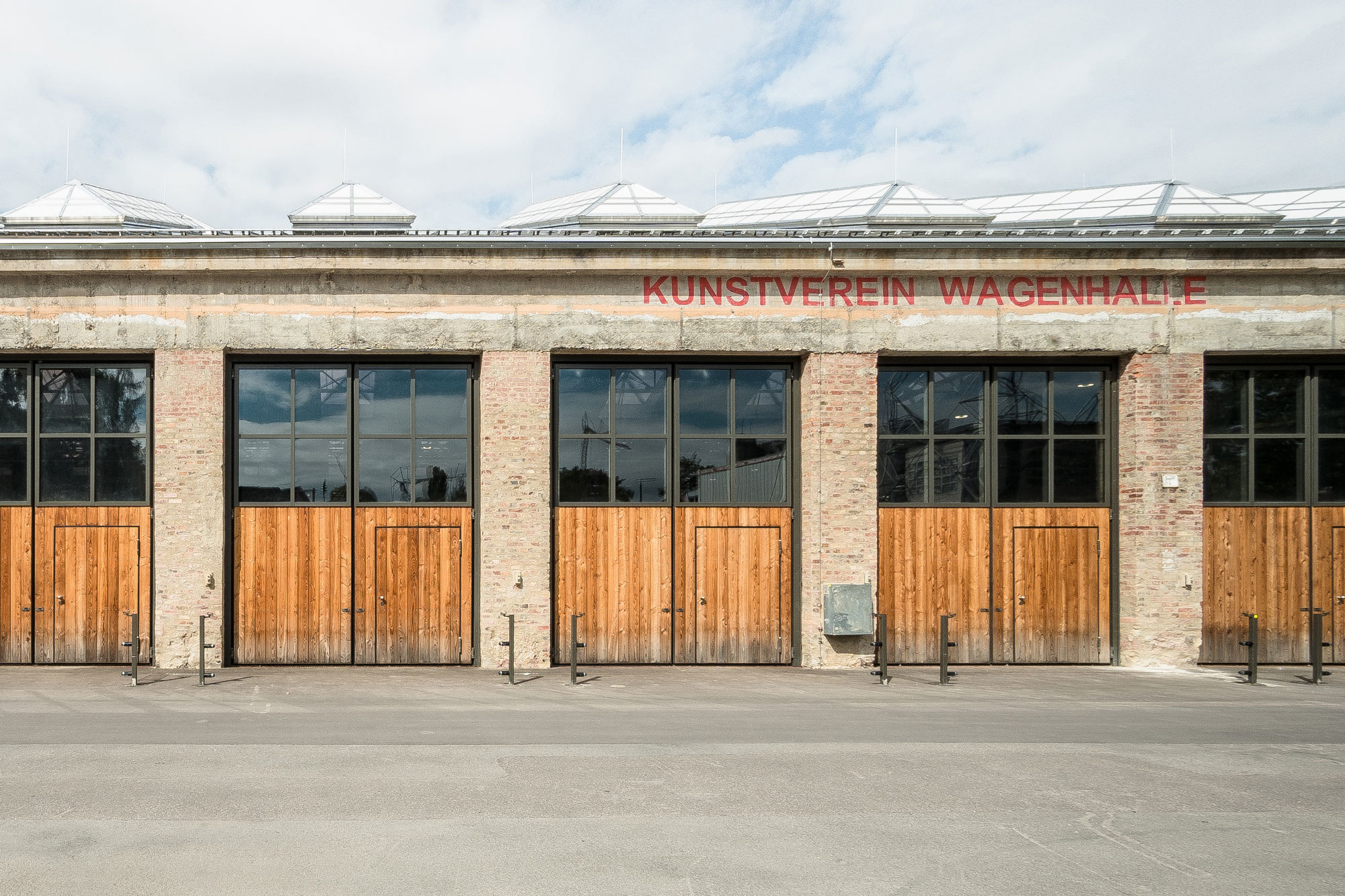 Außenperspektive Hauptfassade der Künstlerateliers mit großen öffenbaren Holz - Glas Toren der Wagenhallen Stuttgart