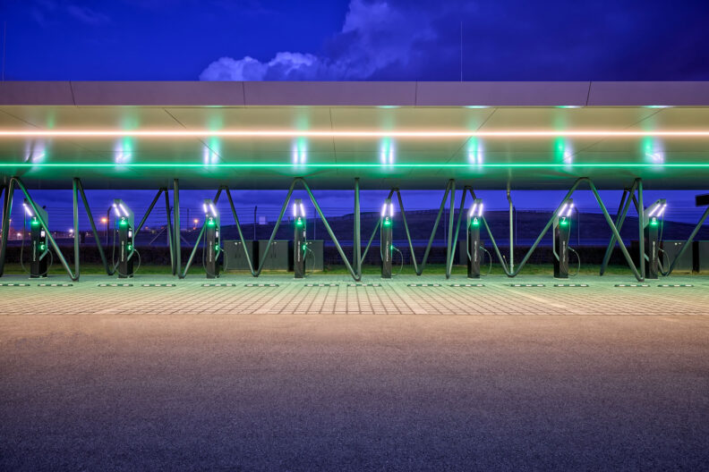 Ansicht der beleuchteten Überdachung der Schnellladestation Porsche Leipzig bei Dämmerung