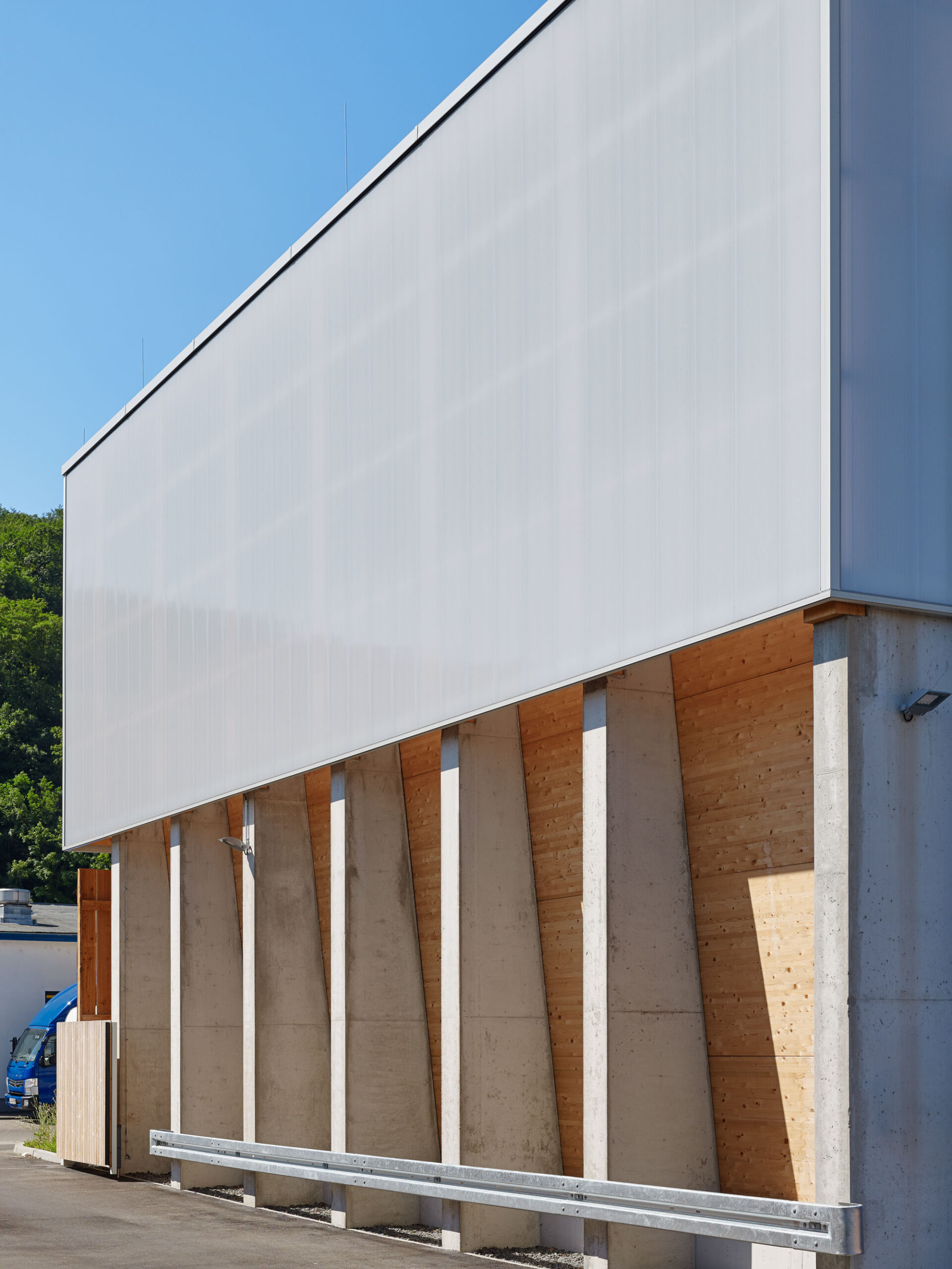 Außenperspektive Fassade mit vielfältiger Materialität aus Stahlbeton, Holz und Polycarbonat des AWS Betriebshof Vogelsang, Stuttgart West/DE