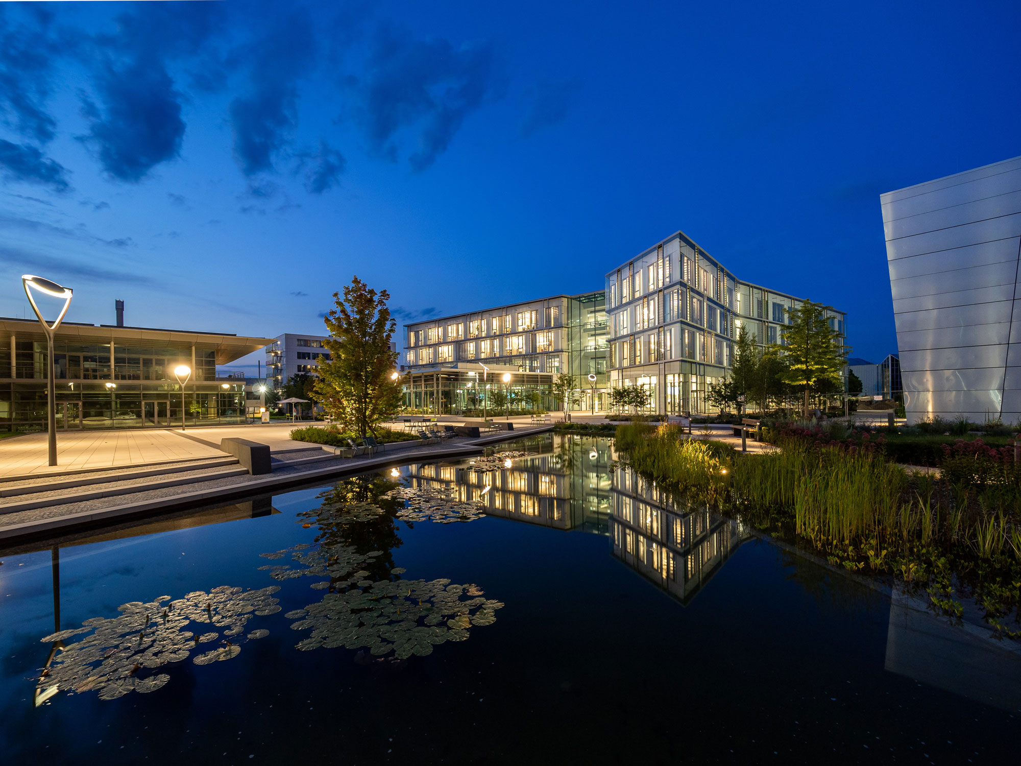 Perspektive Konferenzgebäude Sartorius Campus - Blick über Wasserbecken bei Nacht